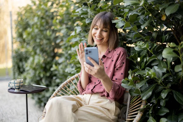 Joven Mujer Alegre Usando Teléfono Inteligente Mientras Está Sentado Fondo — Foto de Stock