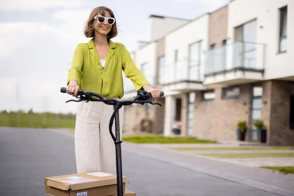 Young Happy Woman Driving Electric Scooter Carrying Cardboard Boxes Street — Stockfoto