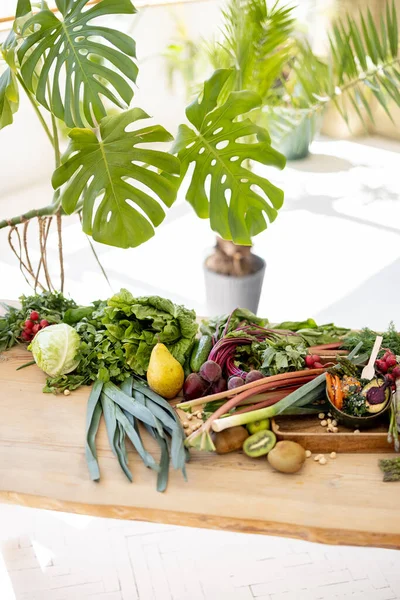 Wooden Table Lots Fresh Vegetables Fruits Greens Indoors Healthy Vegan — Fotografia de Stock