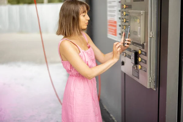 Young Woman Pink Dress Paying Contactless Smart Phone Car Wash — стоковое фото