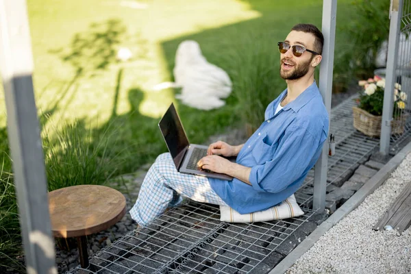 Fajny Facet Pracuje Laptopie Siedząc Zielonym Trawniku Wiejskiego Podwórka Koncepcja — Zdjęcie stockowe