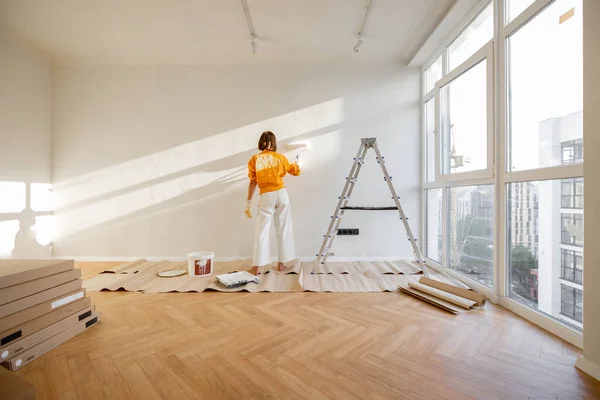 Woman Paints Wall White Color While Making Repairment Newly Purchased – stockfoto