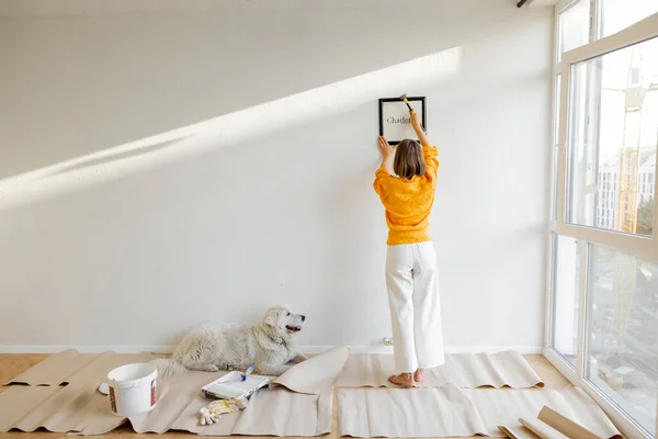 Young Woman Hanging Picture Frame Room Decorating Her Newly Renovated — Stock Fotó