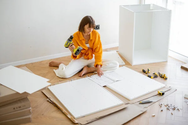 Young Woman Assembles Furniture Herself While Renovating Her New Apartment – stockfoto