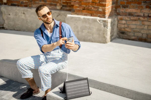 Stylish Man Use Smart Phone Charge Portable Solar Panel While – stockfoto