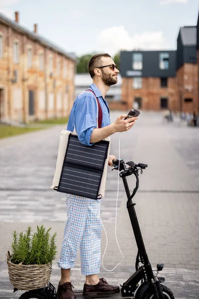 Stilvoller Typ Fährt Elektroroller Und Lädt Handy Mit Solarzelle Unterwegs — Stockfoto