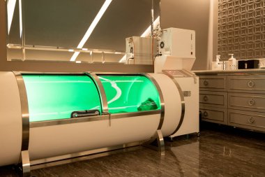 Man lying in oxygen capsule, having deep rest and recovery during the medical procedure of filling the body with oxygen