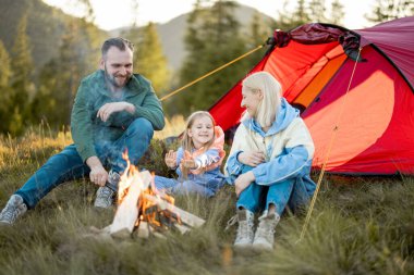 Genç bir çift, küçük bir kızla oturur ve kamp ateşinin yanında güzel sohbetler eder. Doğada çadır kurarak dolaşırlar. Aile yaz tatilini dağlarda yürüyüş yaparak geçirir.