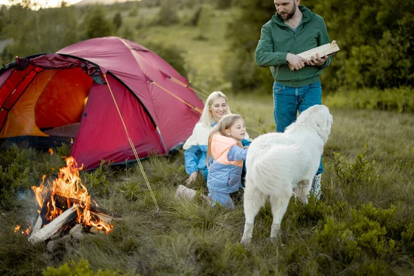 一对年轻夫妇和一个小女孩在营地里玩得很开心 带着帐篷在大自然中旅行 一家人夏天都在山上爬山 人类携带着篝火 — 图库照片