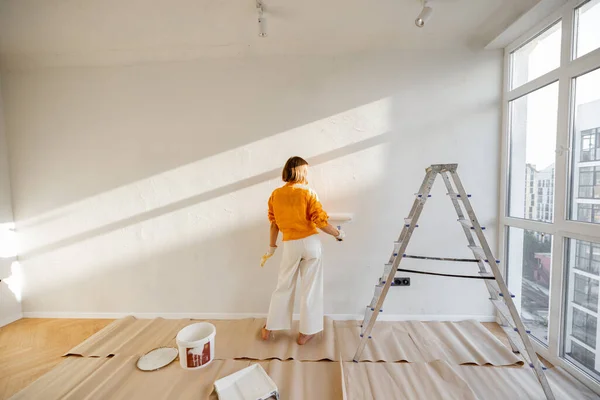 Woman Paints Wall White Color While Making Repairment Newly Purchased – stockfoto