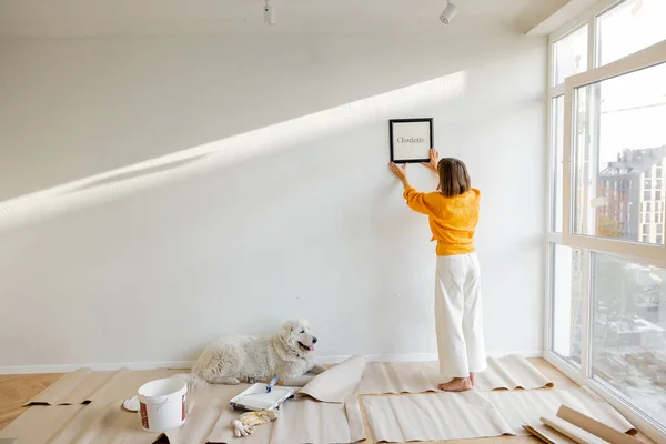 Young Woman Hanging Picture Frame Room Decorating Her Newly Renovated — kuvapankkivalokuva