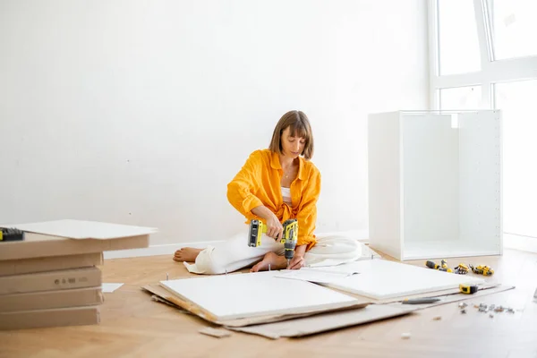 Young Woman Assembles Furniture Herself While Renovating Her New Apartment – stockfoto