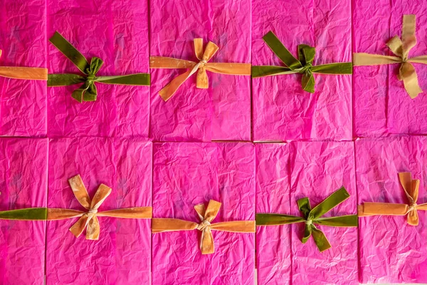 粉色的信封装饰着五彩缤纷的缎带和蝴蝶结堆在桌上 尽收眼底 关于问候和假日主题的背景图像 — 图库照片