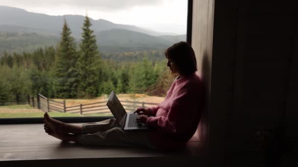 Frau Arbeitet Laptop Während Sie Einem Fenster Mit Herrlichem Blick — Stockvideo