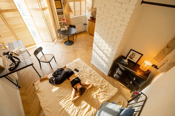 Frau Liegt Entspannt Auf Bett Schönem Und Sonnigem Studio Appartement — Stockfoto