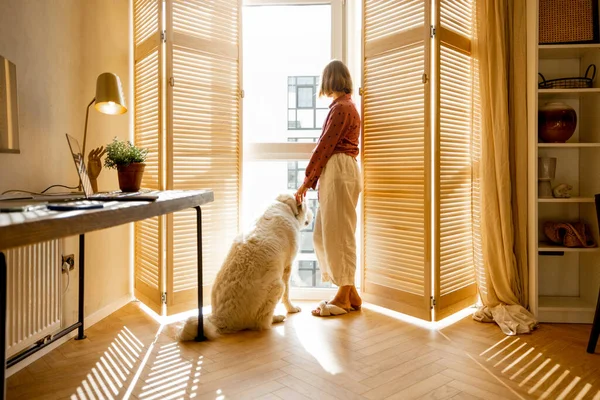 Genç Bir Kadın Köpeğiyle Pencerenin Kenarında Dikiliyor Bej Renkte Modern — Stok fotoğraf