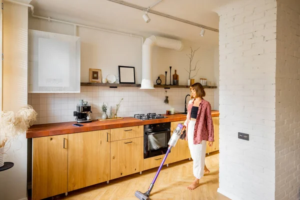 Modern Apartmanın Mutfağında Kablosuz Elektrikli Süpürgeyle Yerleri Süpüren Bir Kadın — Stok fotoğraf
