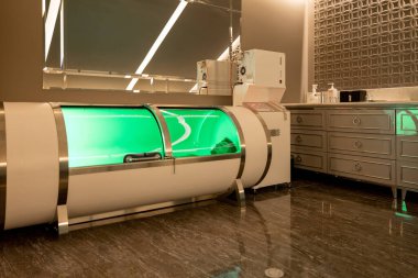 Man lying in oxygen capsule, having deep rest and recovery during the medical procedure of filling the body with oxygen