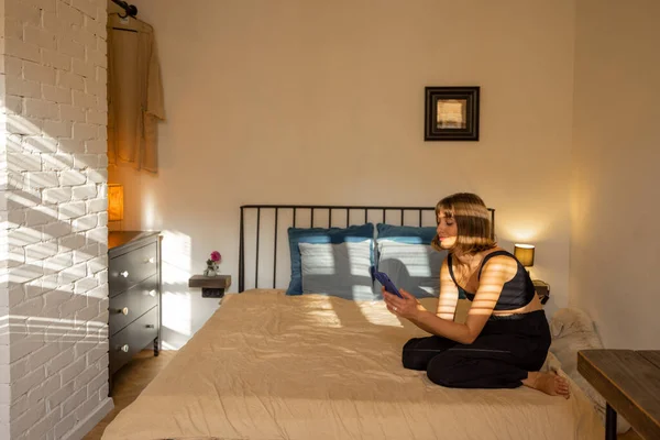 Frau Benutzt Smartphone Während Sie Entspannt Auf Dem Bett Schönen — Stockfoto