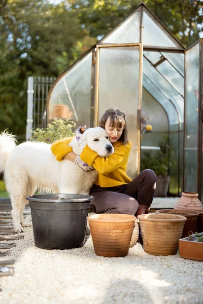 Jovem Mulher Abraços Com Seu Cão Adorável Enquanto Plantando Flores — Fotografia de Stock