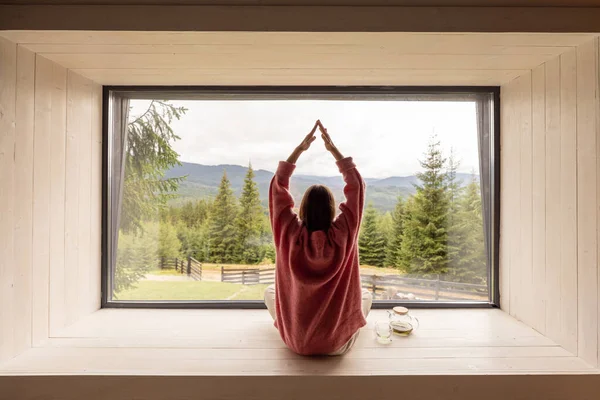 Frau Meditiert Auf Fensterbank Sitzend Und Genießt Panoramablick Auf Berge — Stockfoto