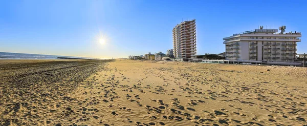 Güneşli bir günde Jesolo 'nun altın plajı ve açık mavi gökyüzü