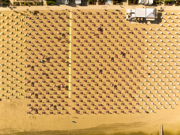 Jesolo, güverte sandalyeleri ve yaz şemsiyesiyle yukarıdan görünen plaj.