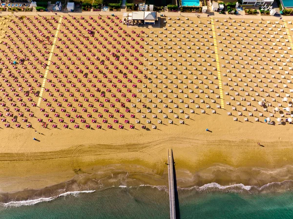 Jesolo plajı güverte sandalyeleri ve yaz şemsiyesiyle yukarıdan görünüyor.