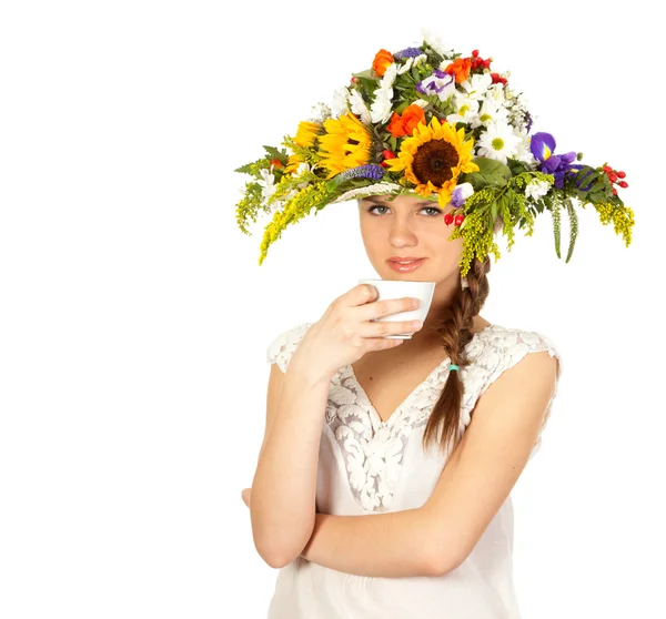 Beautiful girl in hat of flowers and cup of tea — Stock Photo, Image