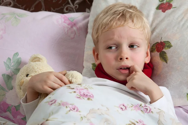 Ziek jongen ligt in bed — Stockfoto
