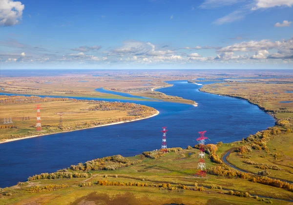 Power line runs above the river — Stock Photo, Image