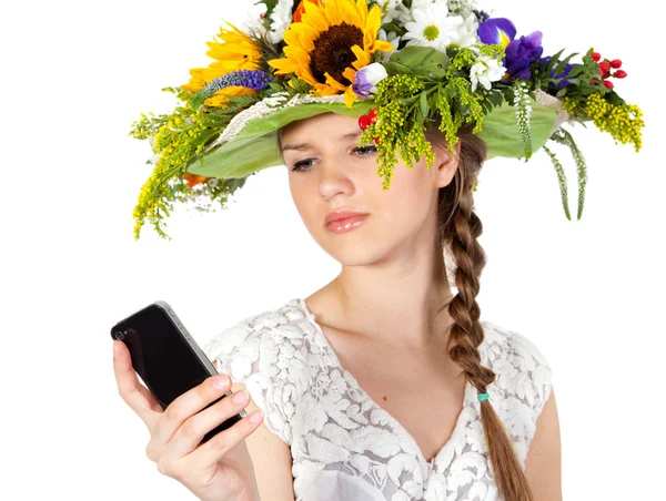 Όμορφο κορίτσι στο καπέλο των λουλουδιών και τηλέφωνο美丽的女孩，戴着帽子的花儿和电话 — Stockfoto