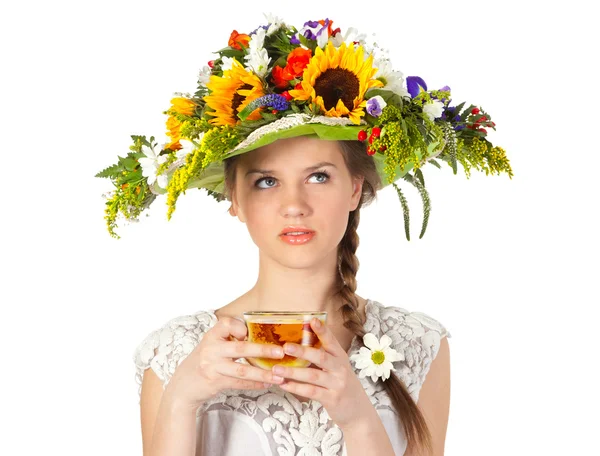 A szép lány a kalap, a virágok és a csésze tea — Stok fotoğraf