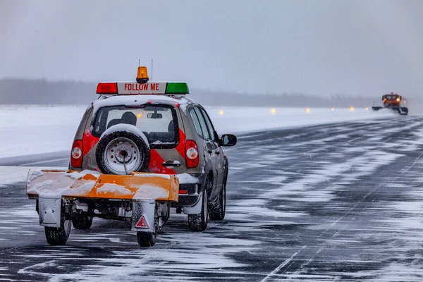 Pługi śnieżne na pasie startowym podczas burzy śnieżnej Obrazek Stockowy