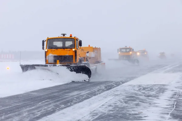 Arado de nieve en la pista en una tormenta de nieve Fotos de stock libres de derechos