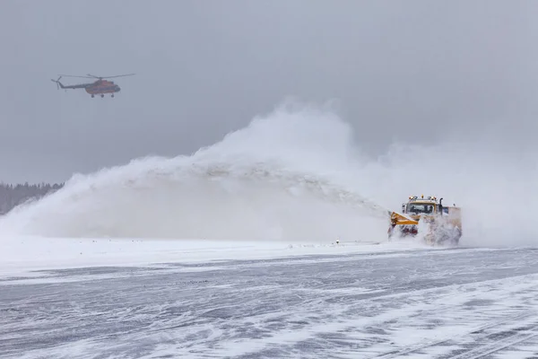 Arado de nieve en la pista en una tormenta de nieve Fotos de stock