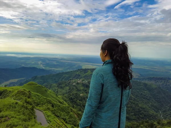 Kurseong Darjeeling Batı Bengal Hindistan 'da sabah dramatik gökyüzü ile dağın tepesinde duran kız görüntüsü çekilmiştir..