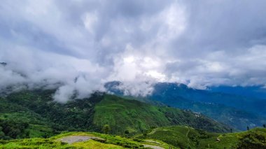 Tepeden yukarıya doğru dramatik gökyüzü olan yeşil dağ Darjeeling Batı Bengal Hindistan 'da çekilmiştir..