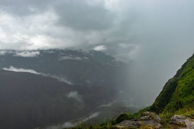 Yağmurlu bir günde dramatik bulutlu gökyüzü olan sisli dağlar Hindistan 'ın en yüksek latilyum zirvesinde görüntülenir..
