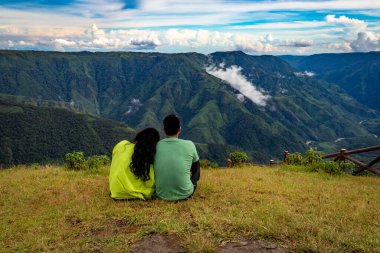 İzole genç çift dağ vadisi ve dramatik gökyüzü görüntüsüyle birlikte tepenin zirvesinde birlikte zaman geçiriyorlar. Hindistan 'ın en yüksek latilyum zirvesinde..