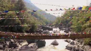 Pek çok Budist kutsal bayrakla eşsiz bir bakış açısıyla antik kutsal bambu köprüsü.