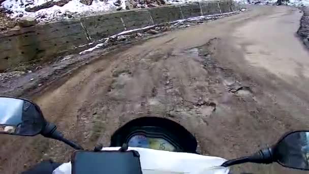 バックグランドに雪の帽子の山がある人里離れたヒマラヤの孤立した道路で自転車に乗る — ストック動画