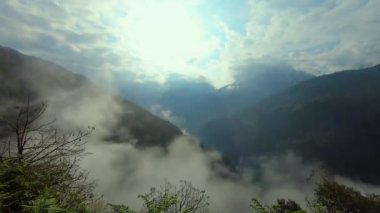 Yoğun alçak bulutlar ve dağ zeminiyle kaplı karamsar bir gökyüzü.