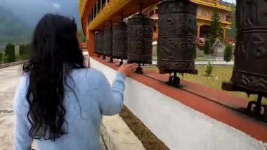 Kız manastırda Budizm 'in kutsal tekerleklerini düz açıyla döndürüyor.