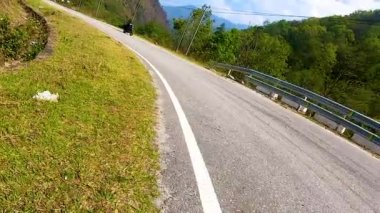 Himalayalar 'da sabah alçak açılı virajlı yolda motosiklet sürüyorum.