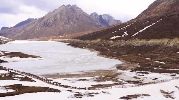 雪のキャップの山と青い空と凍るような瀬の湖フラット角度から朝 — ストック動画