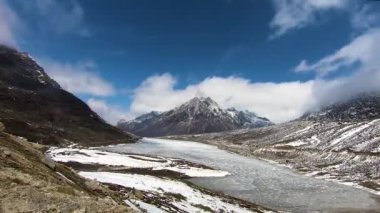 Donmuş gölü ve parlak mavi gökyüzü olan kar örtüsü dağlarının düz açılı zamanı.