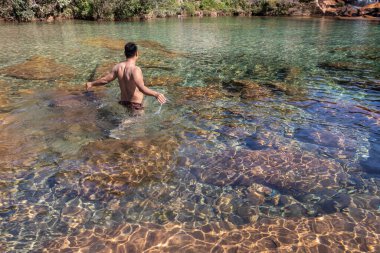 Genç adam, sabahleyin nehir kenarında durarak düz açılı görüntüden Mawasawa Cherrapunji Meghalaya Hindistan 'da çekilmiştir..