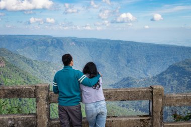 Genç çift, öğleden sonra açık mavi gökyüzü ile dağ sırasını seyrediyor. Düz açılı görüntü, yedi kardeş şelale Cherrapunji meghalaya Hindistan 'da çekildi..