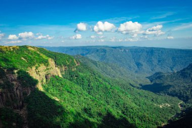 Akşamüstü yeşil ormanlarla kaplı dağ sıraları ve açık mavi gökyüzü düz açılı görüntüler yedi kardeş şelale Cherrapunji meghalaya Hindistan 'da çekildi..